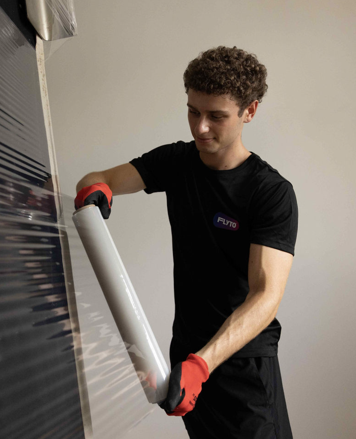 Moving company worker wrapping boxes with protective stretch film
