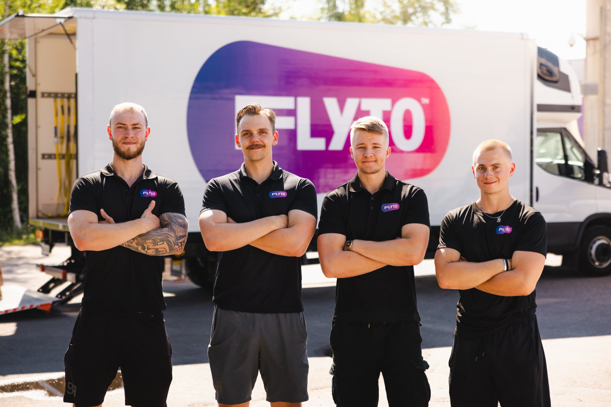 FLYTO moving company team standing in front of branded truck