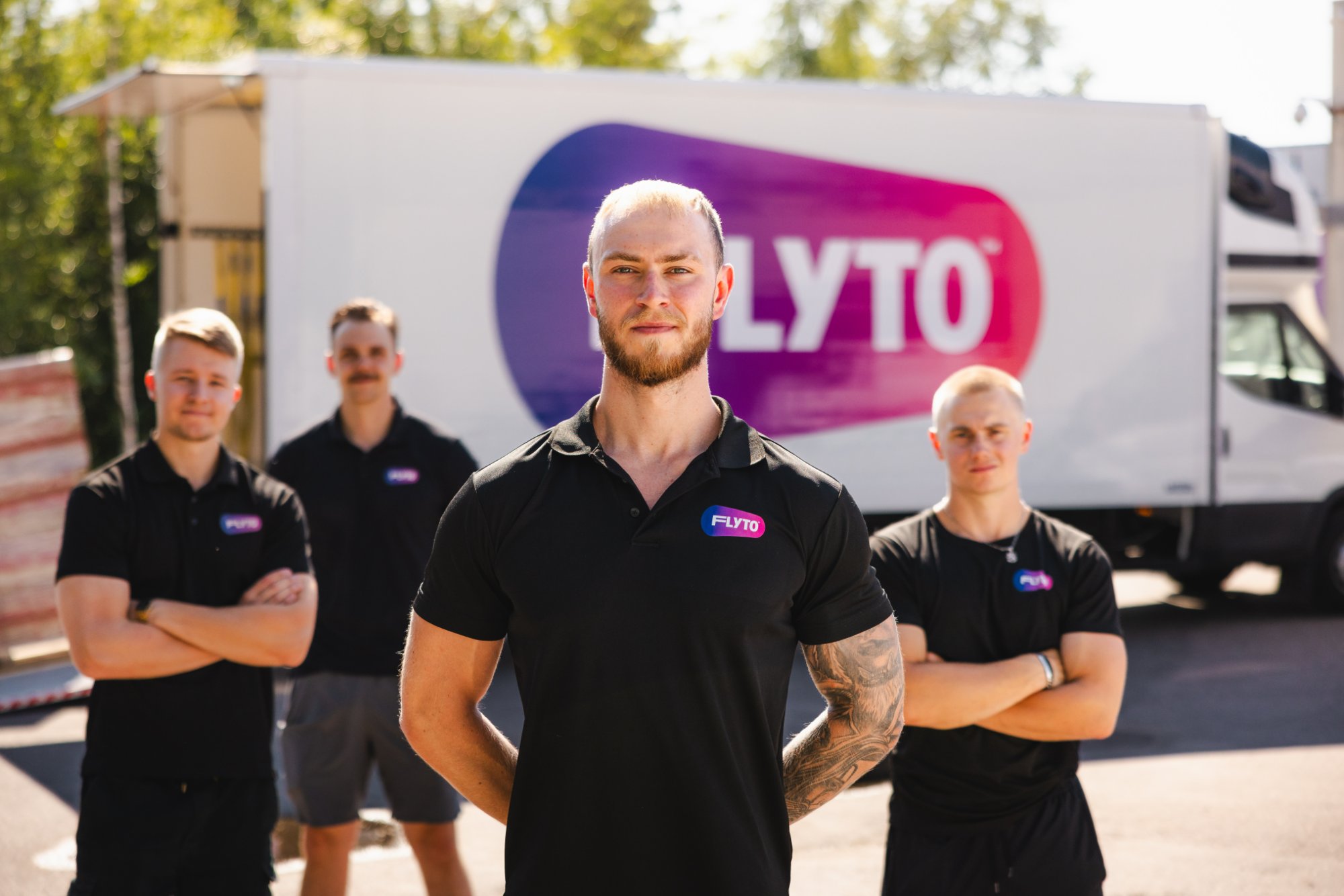 FLYTO moving company team standing in front of branded truck