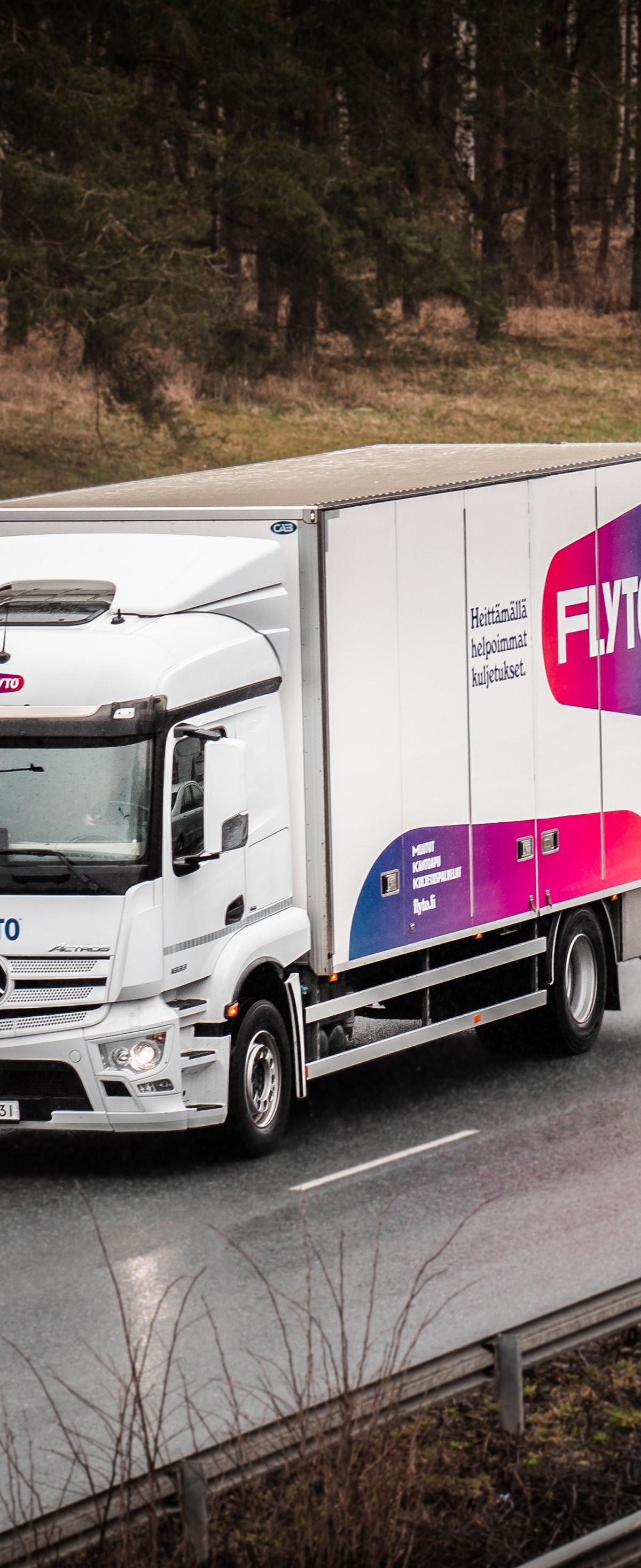 FLYTO moving truck on Nordic highway passing through birch forest