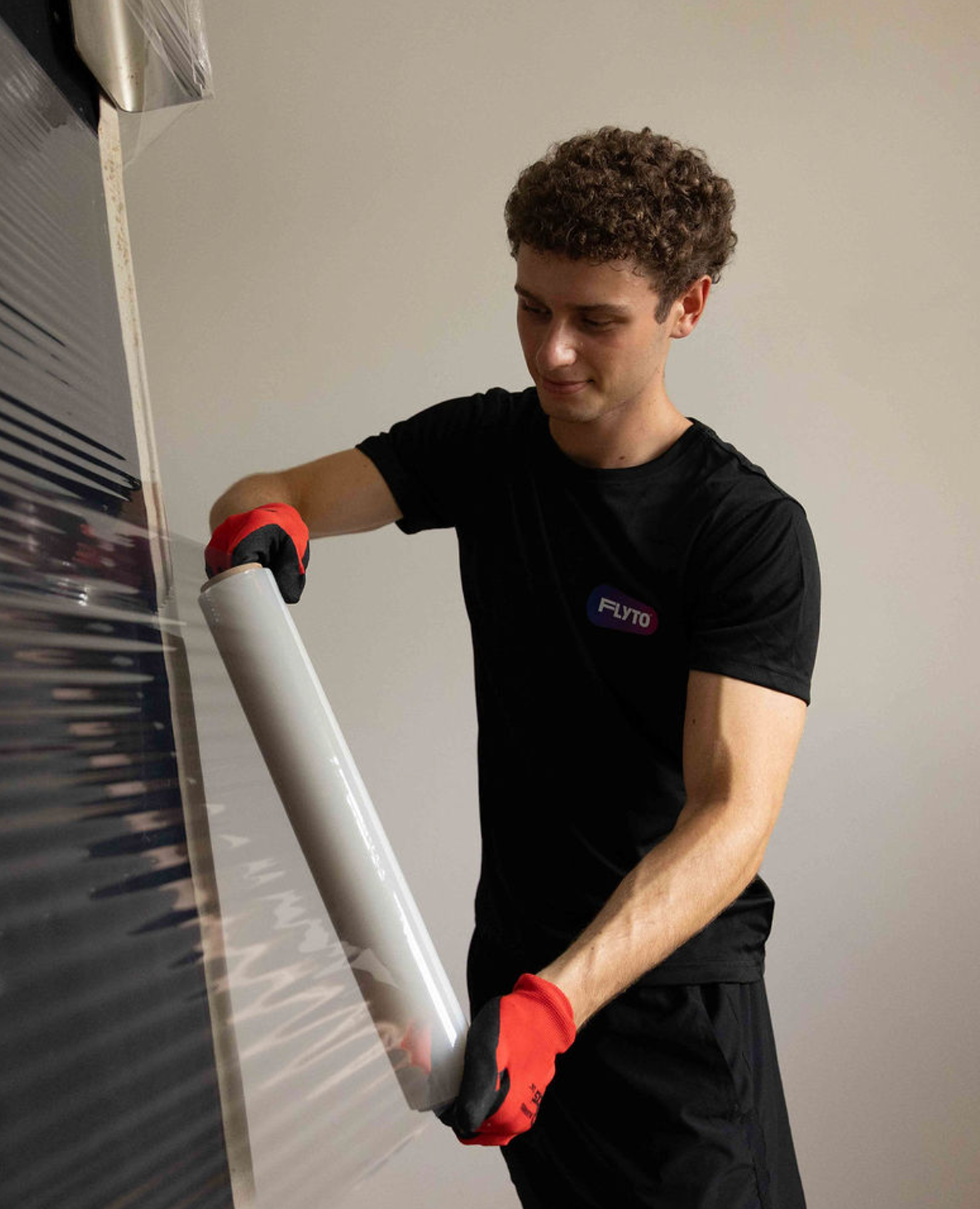 Moving company worker wrapping boxes with protective stretch film