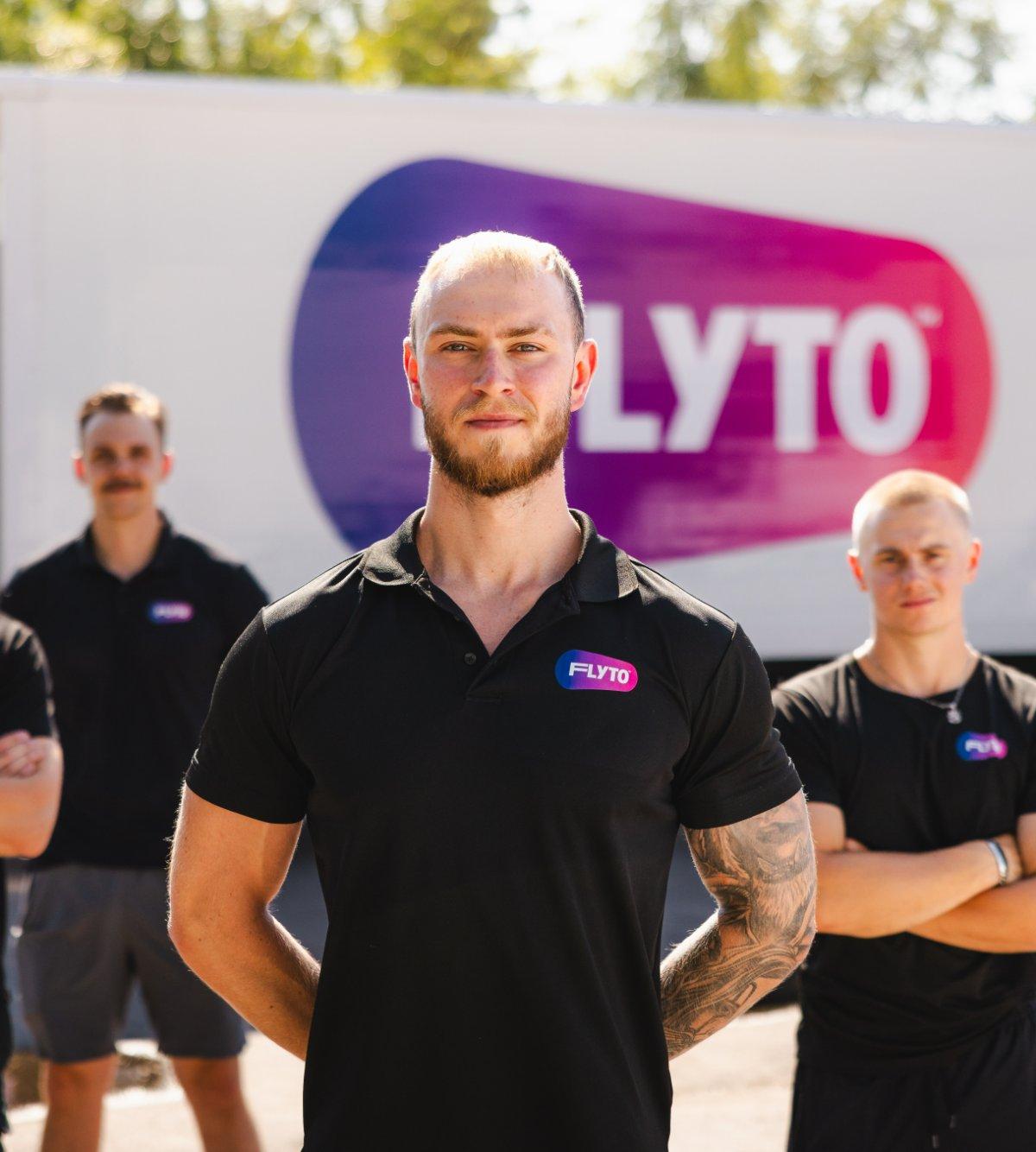 FLYTO moving company team standing in front of branded truck