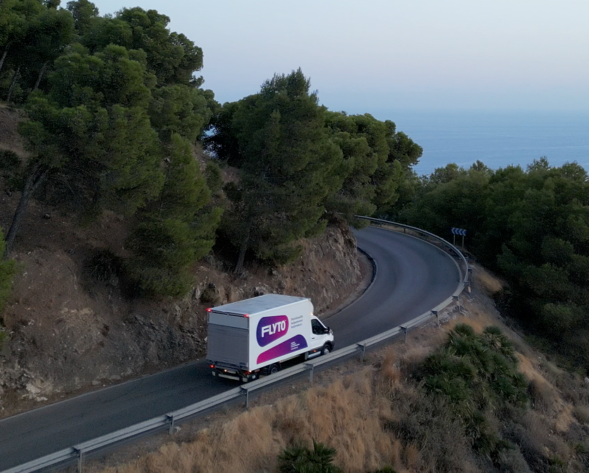 FUTO moving van on curved mountain road with sea view